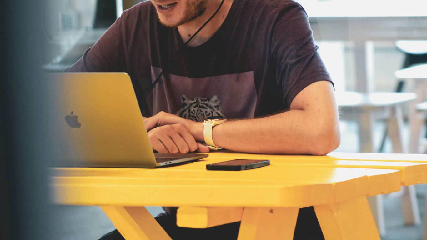 man in black crew neck t-shirt using silver macbook