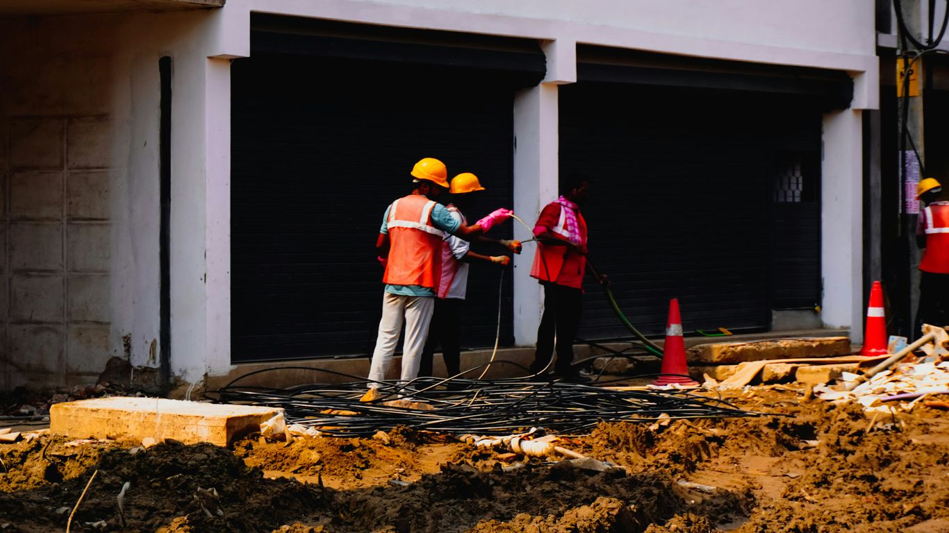 Construction workers in hard hats near a building