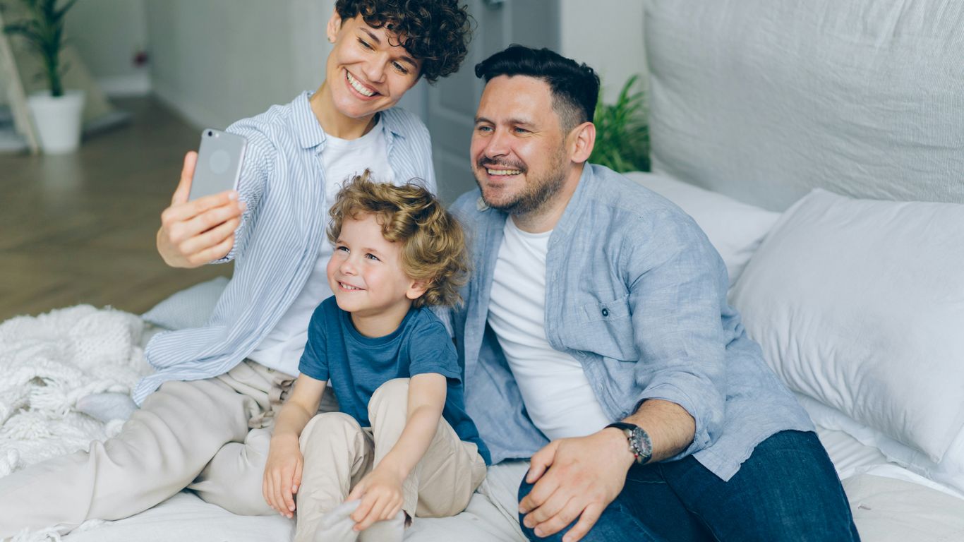 a man and two children sitting on a bed
