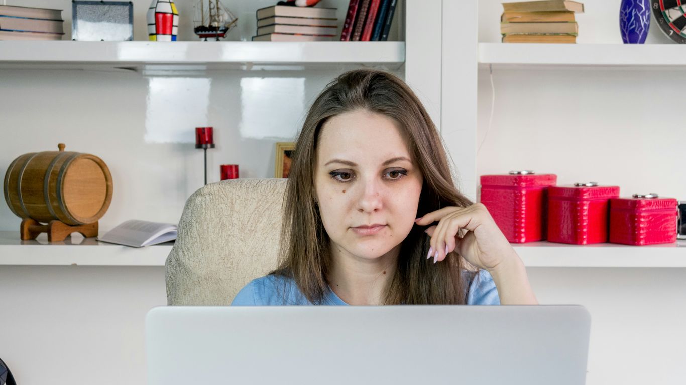 a woman sitting in front of a laptop computer