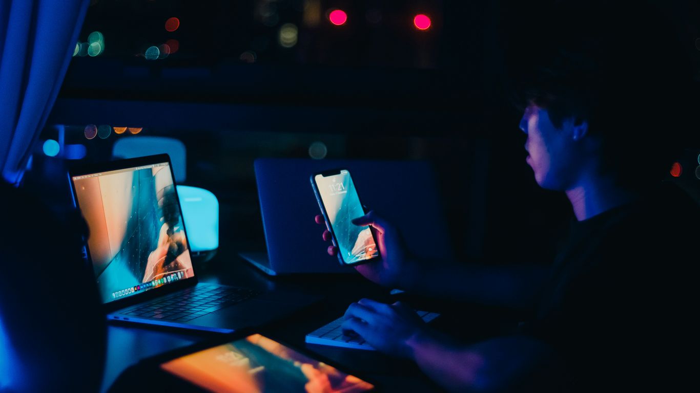 a man sitting in front of a laptop computer