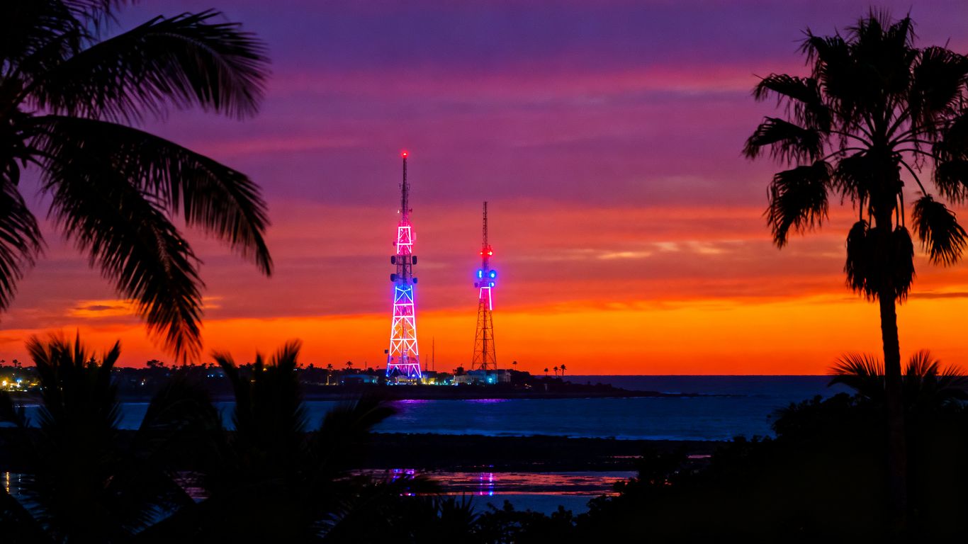 San Diego skyline with telecom towers at dusk.