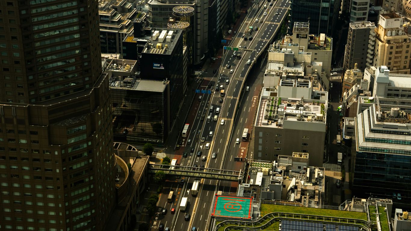 Busy highway traffic amidst tall city buildings