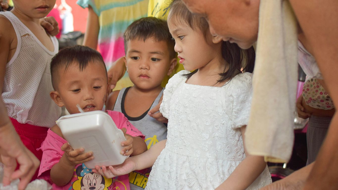 a group of children standing around each other
