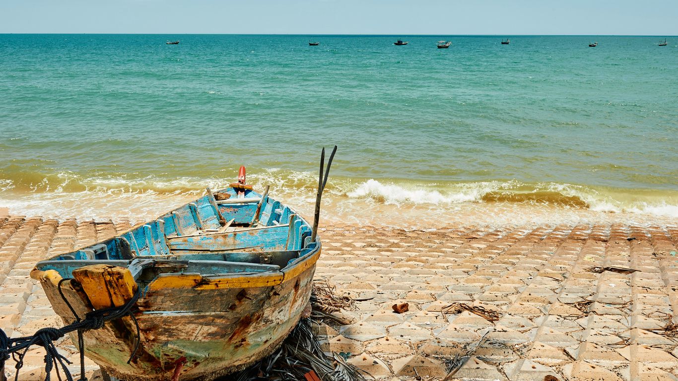 Old wooden boat beside a tropical shoreline