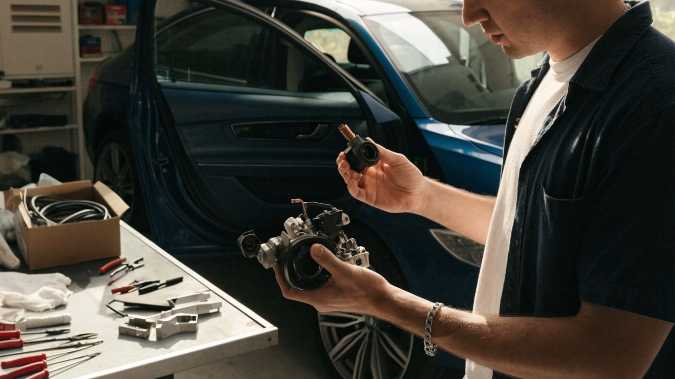 Technician checking a BMW component beside car