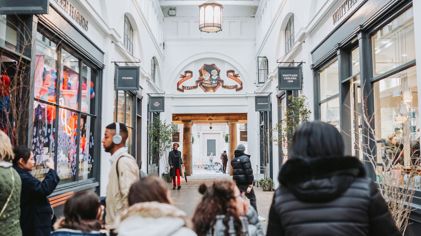 a group of people walking through a shopping mall