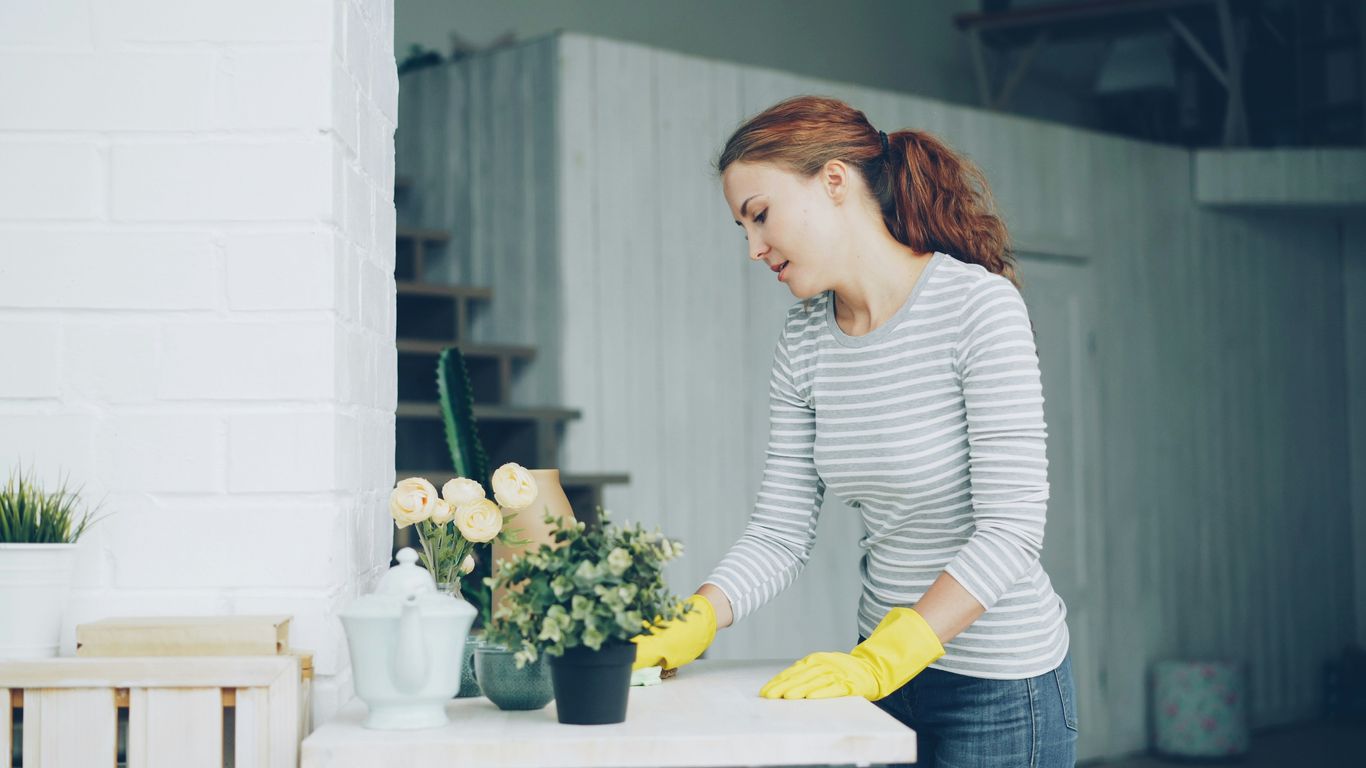 A person gently cleaning a floral arrangement