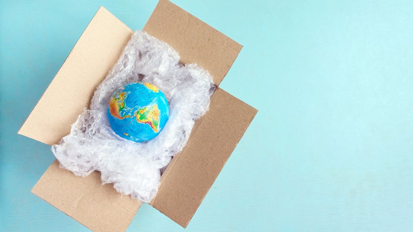 A globe is packed in bubble wrap inside a cardboard box.