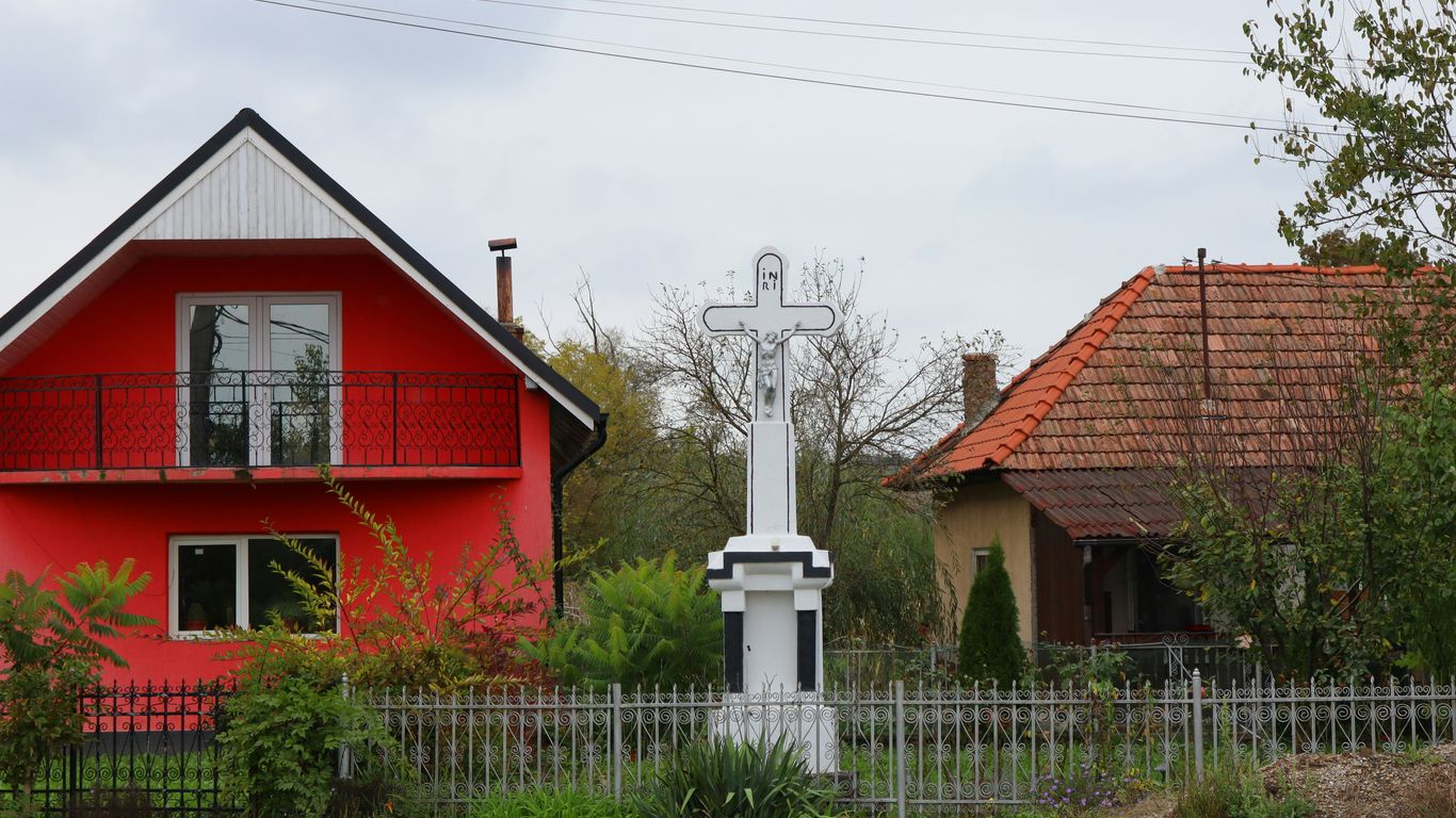A red house with a white clock in front of it