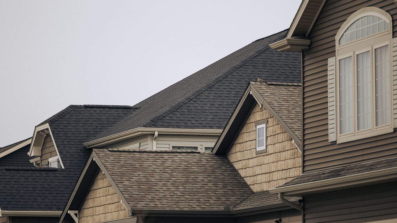 a row of houses with brown shingles and white windows
