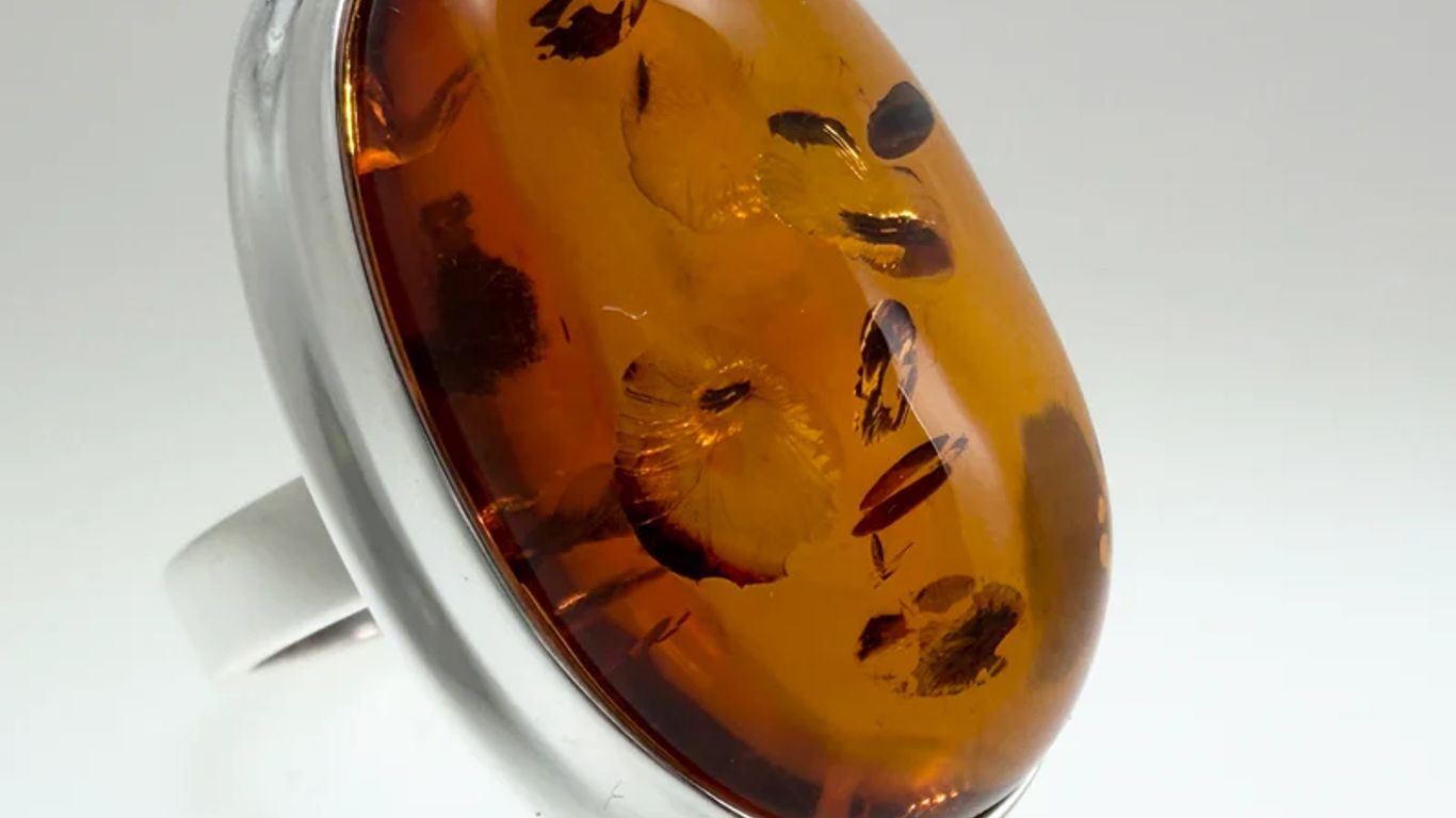 A large oval amber ring with inclusions, set in silver.