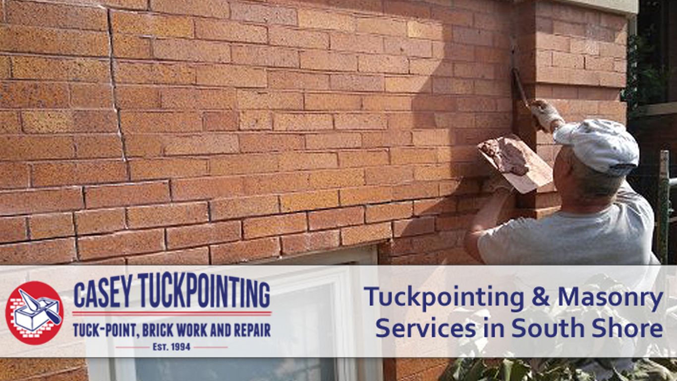 Masonry worker repairing a brick wall with tuckpointing services.