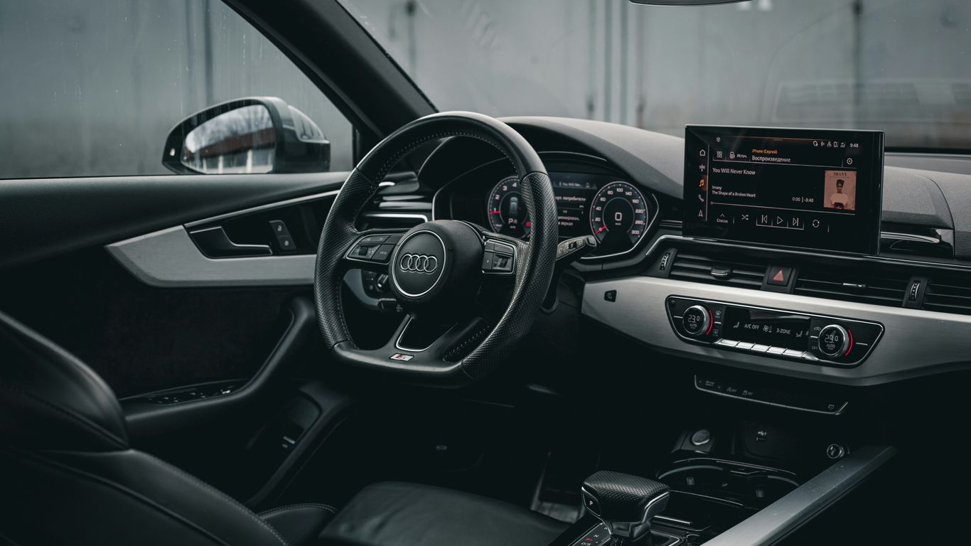 Audi key fob beside a luxury car