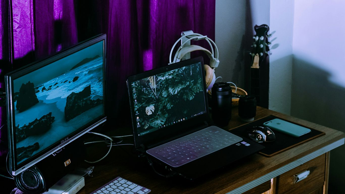 black laptop computer on brown wooden table