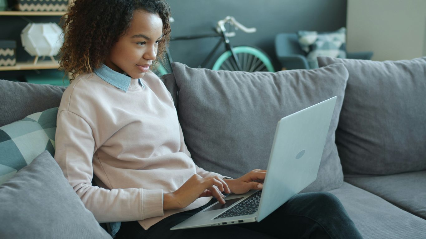Woman working on a laptop on a couch