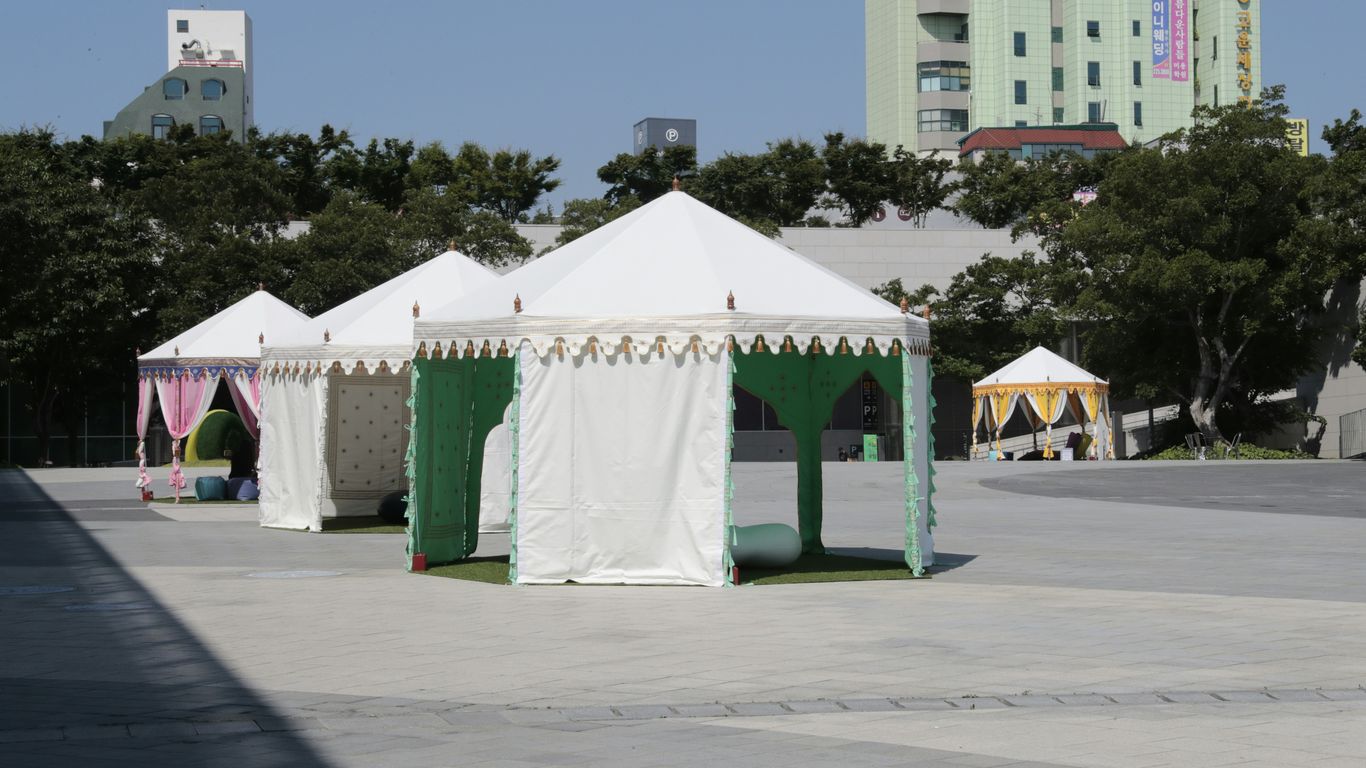 white and green tent near green trees during daytime