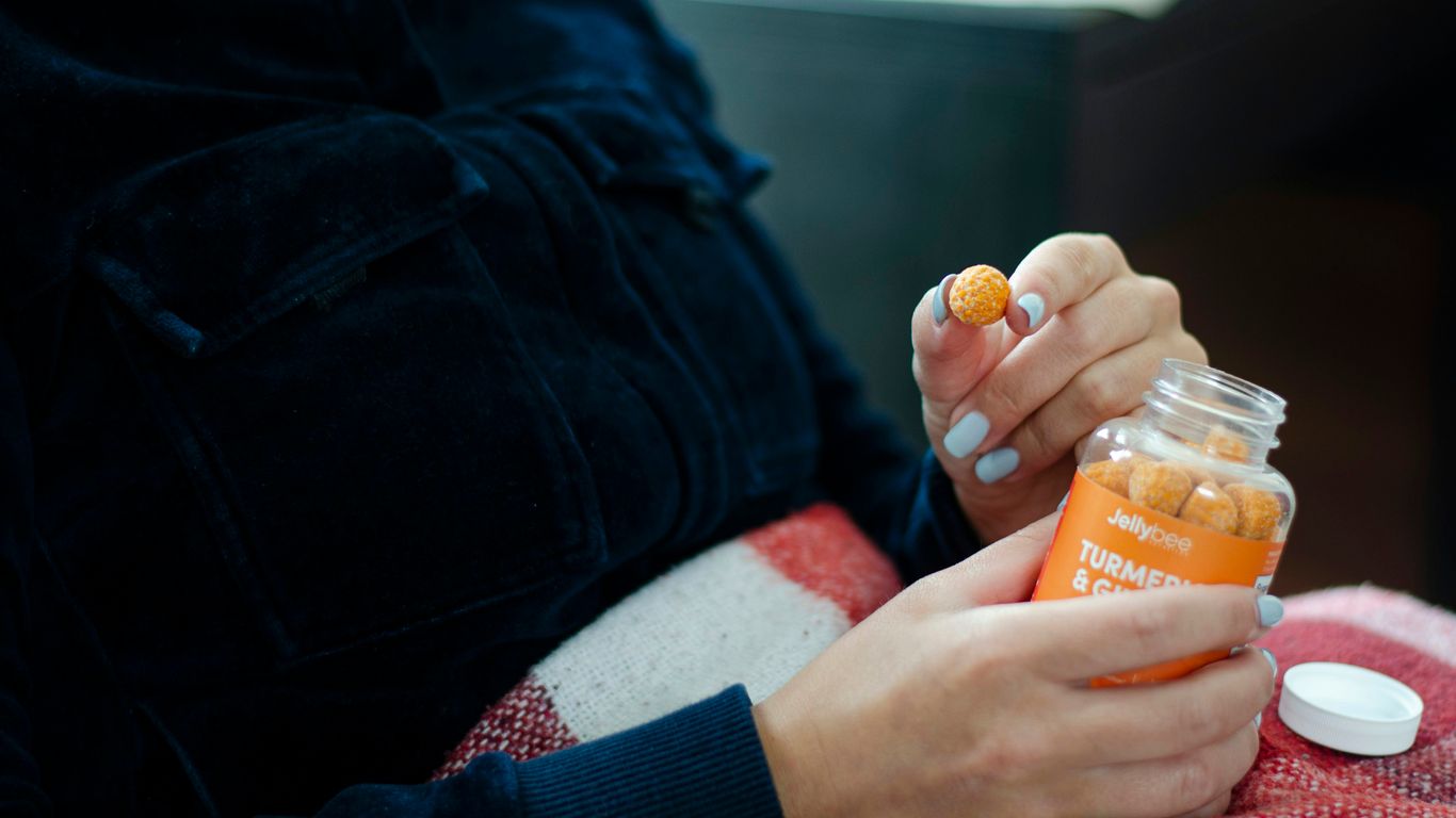 person holding orange plastic bottle