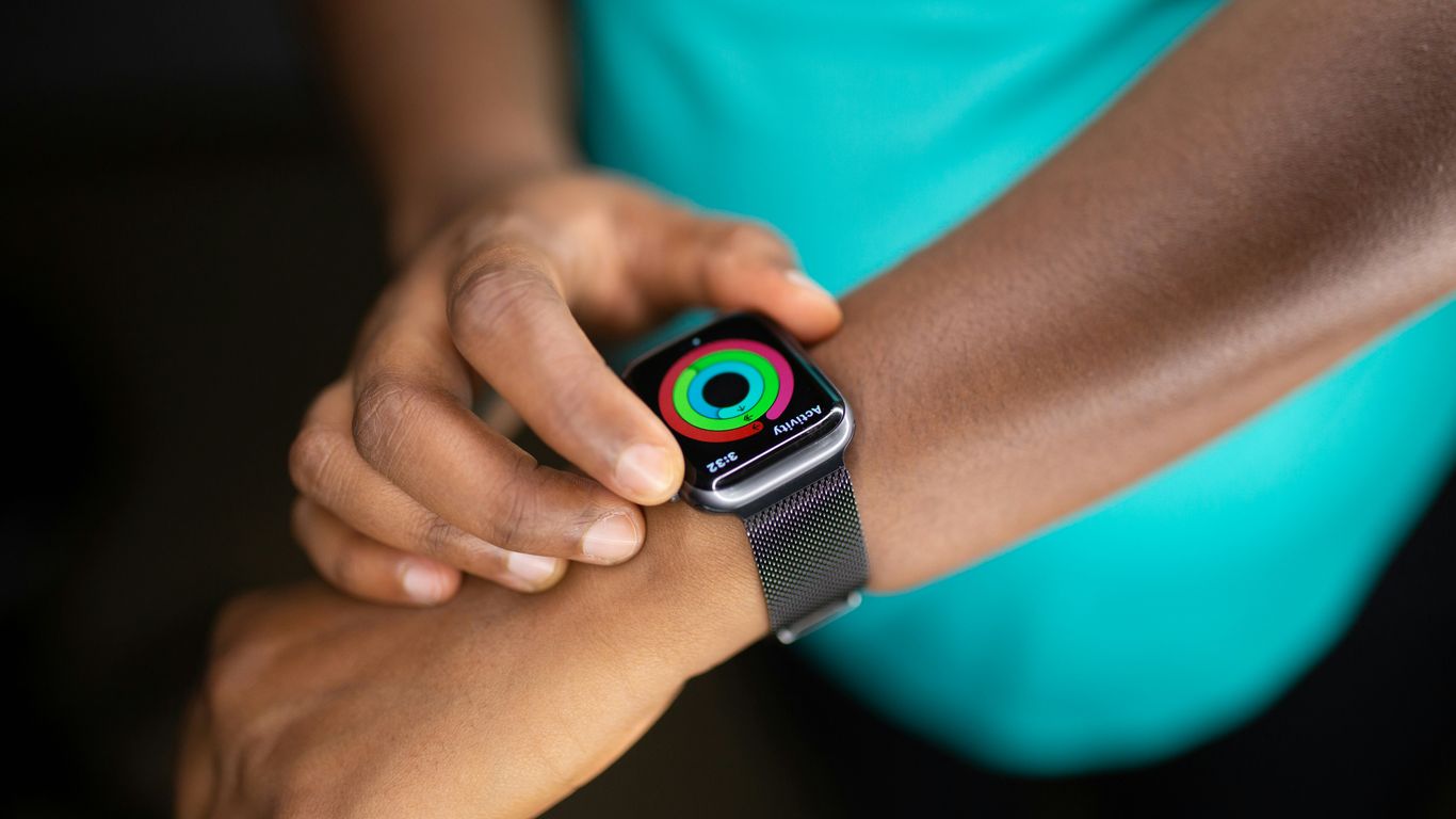 person wearing silver aluminum case apple watch with white sport band