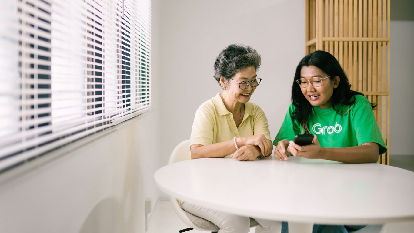 a couple of women sitting at a white table
