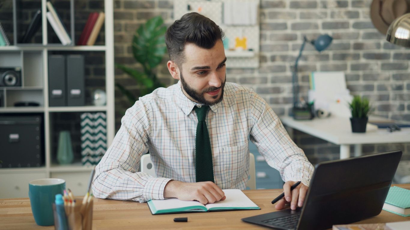 Werknemer controleert werkdocumenten op een laptop