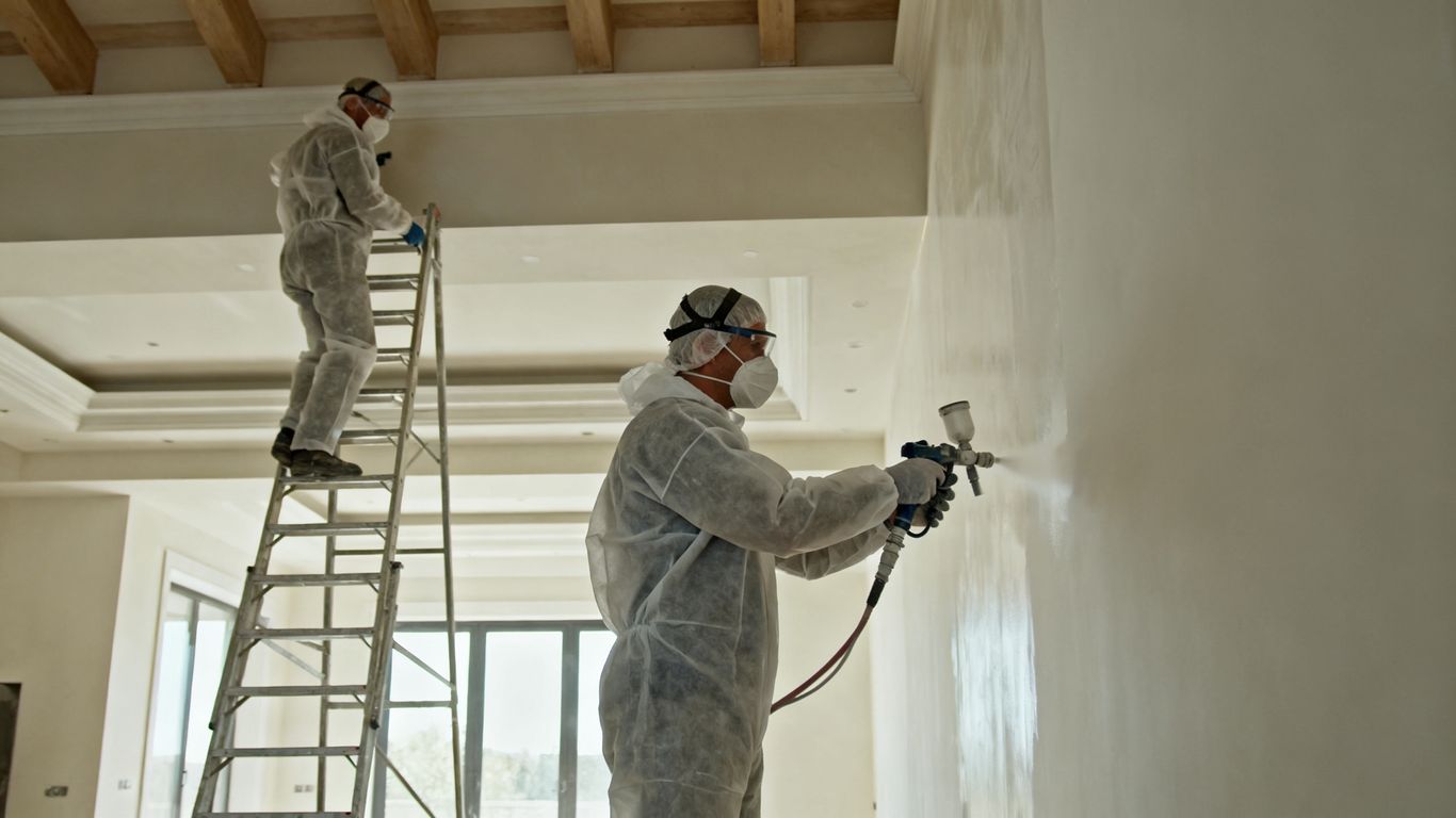 Two painters coordinating on a busy new construction floor