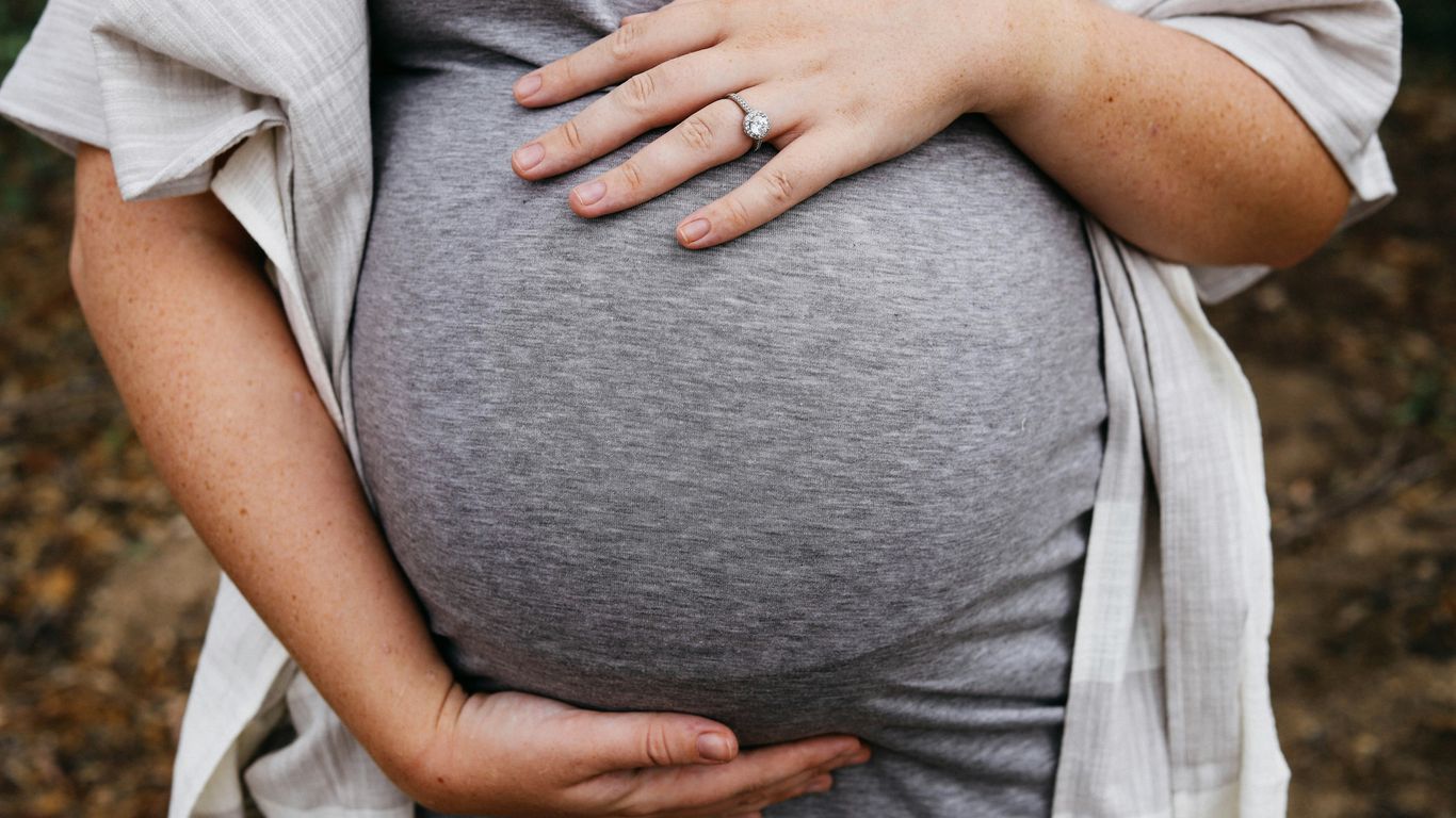 a pregnant woman holding her belly in her hands