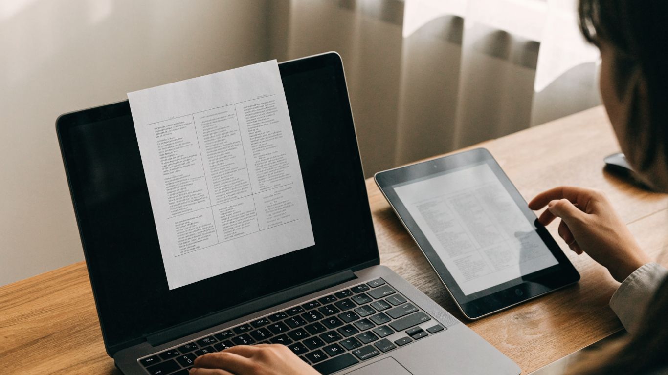 Reviewer comparing two document drafts at a desk