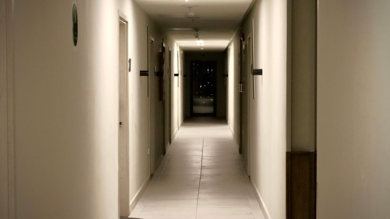 Long apartment corridor with colourful household doors