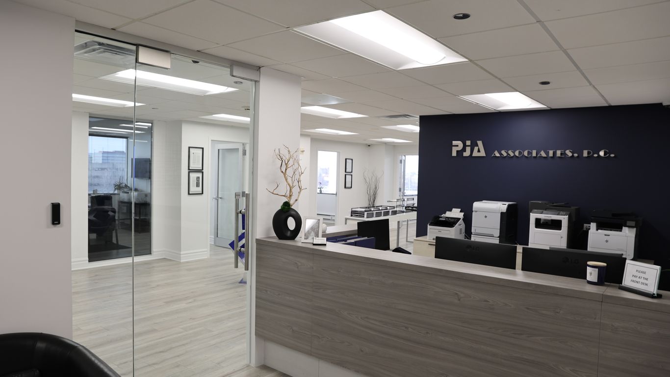 Modern office reception area with a dark blue wall and wood-grain desk.