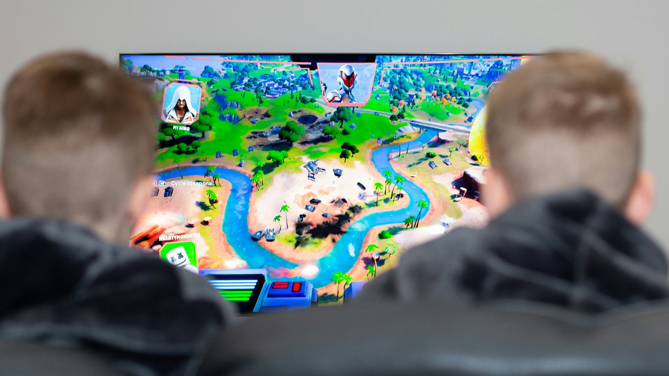 two boys are playing a video game on the television
