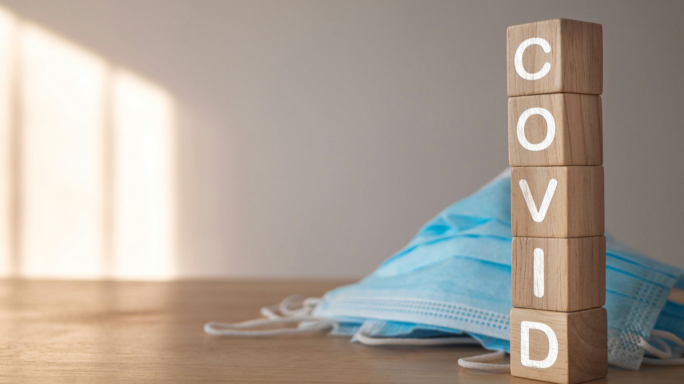 a wooden block with the word covid written on it