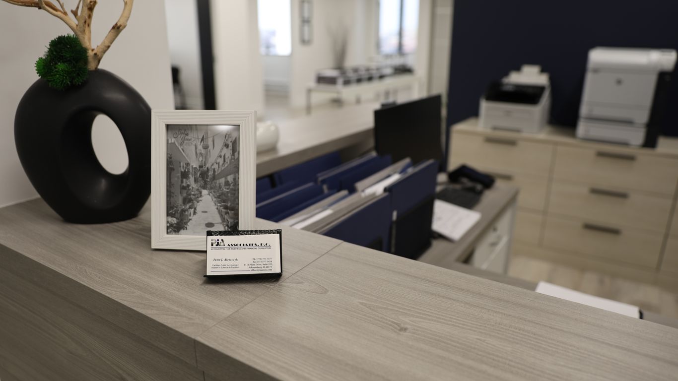 Office reception desk with a vase, picture frame, and business card.