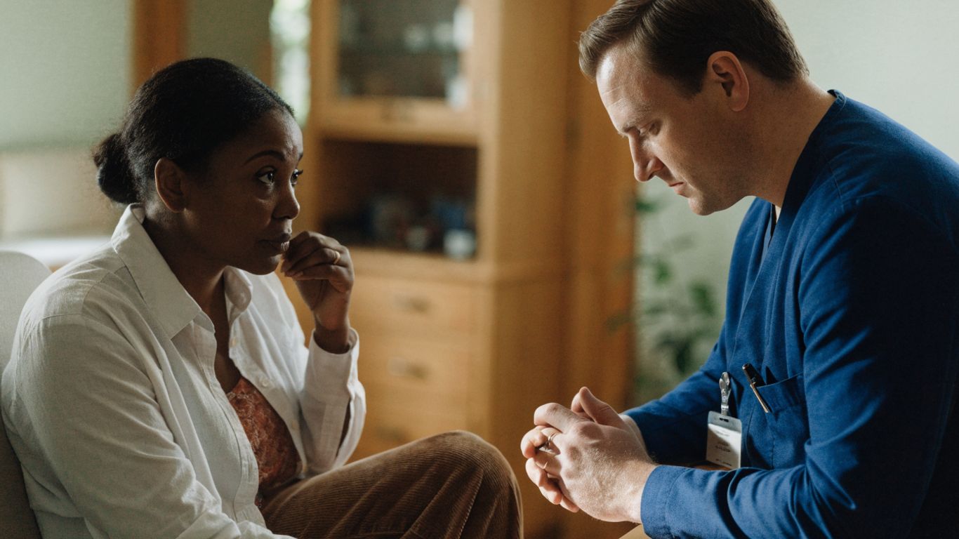 Médecin échangeant calmement avec un patient en consultation