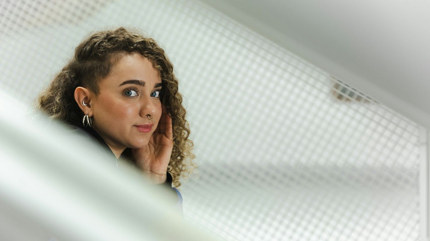 Young woman poses looking over her shoulder.