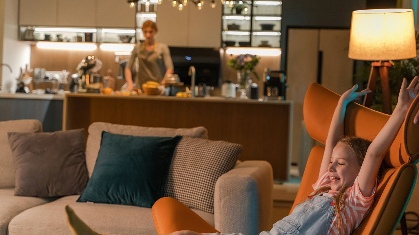 a little girl sitting in a chair in a living room