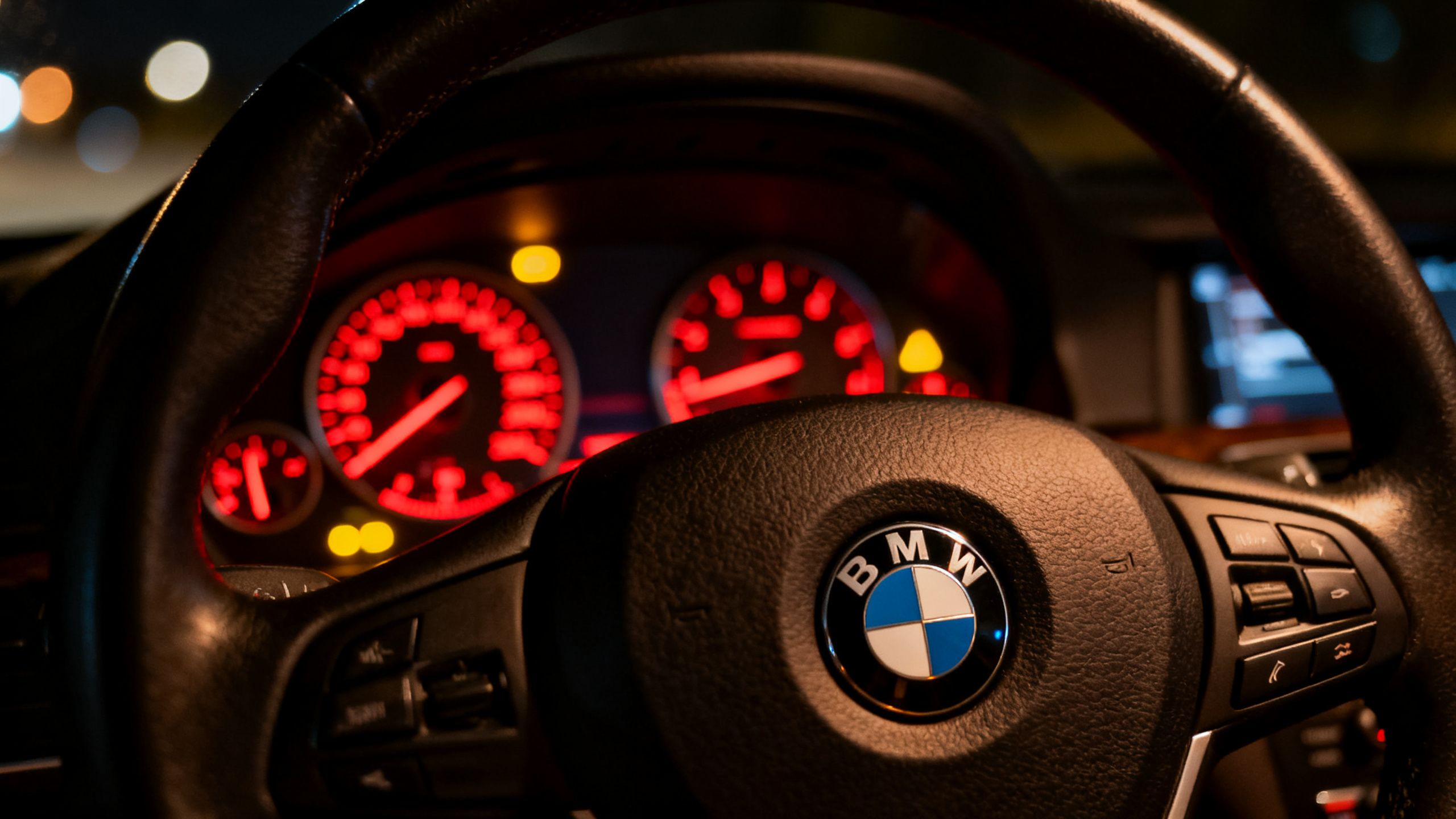 BMW dashboard with warning lights illuminated and BMW steering wheel logo.