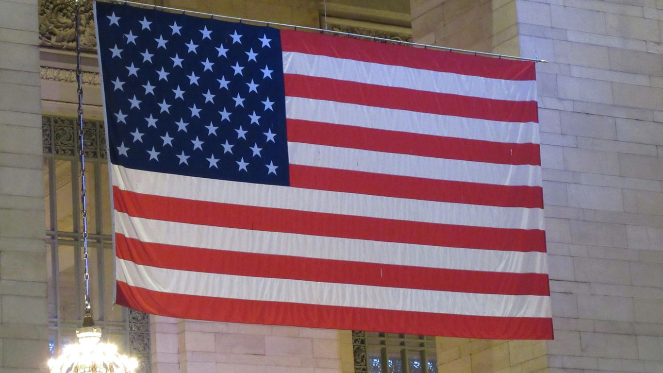 American flag hanging in a grand building interior.