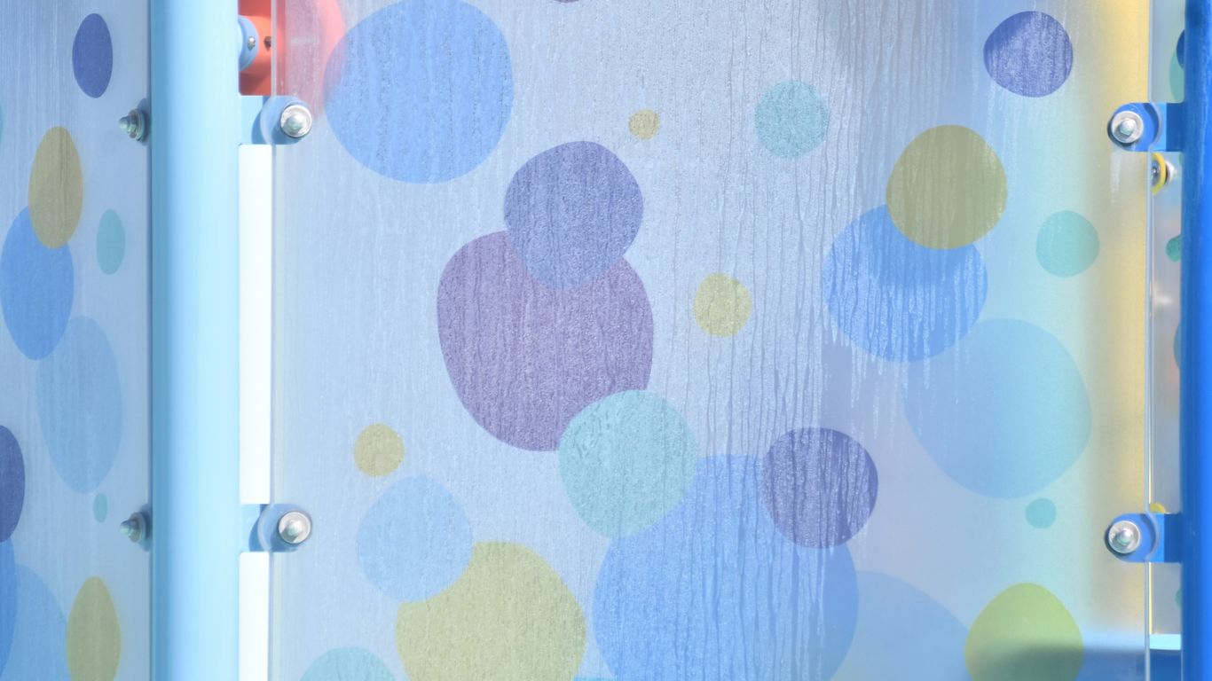 Close-up of a blue shower curtain with colorful bubbles.
