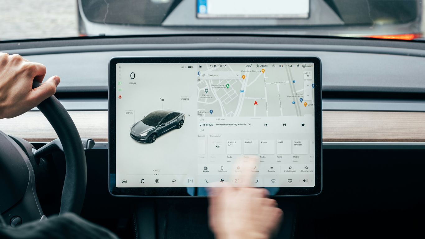 a person driving a car while holding a tablet