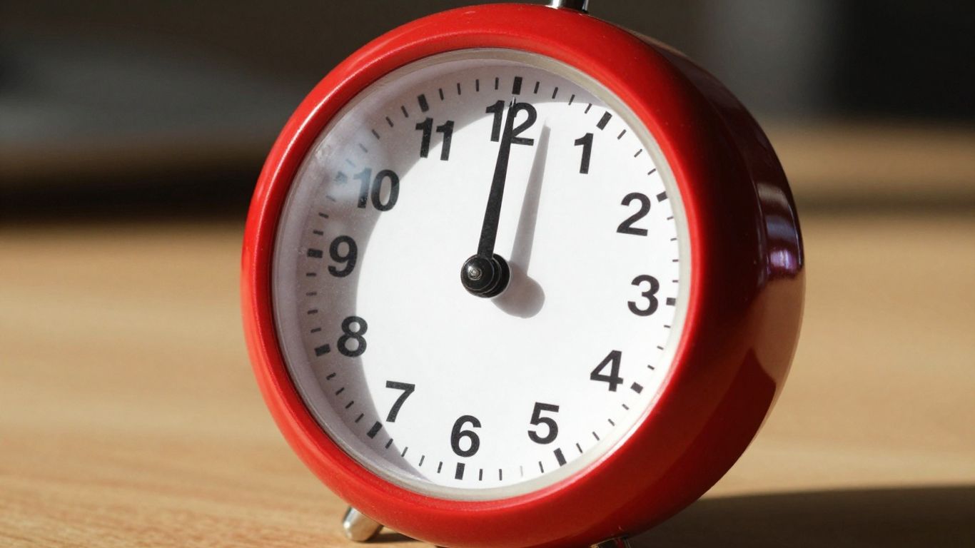 Red Pomodoro timer ticking on a desk.