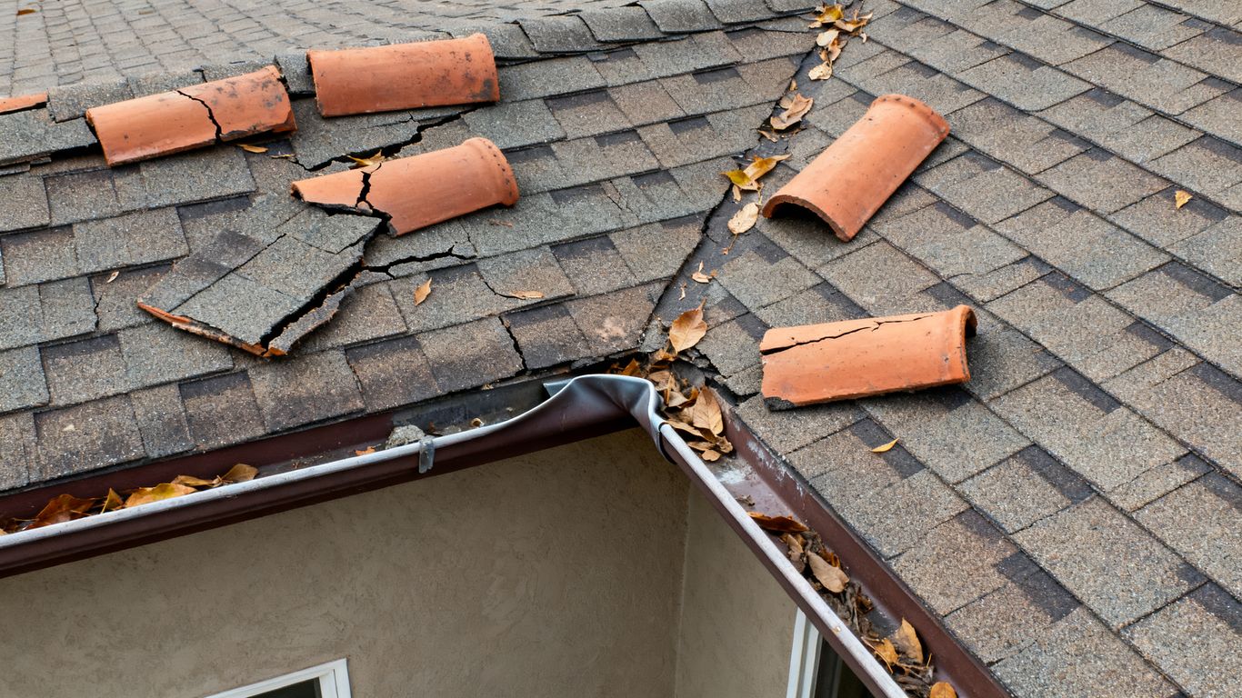 Drone view showing damaged residential roof after storm