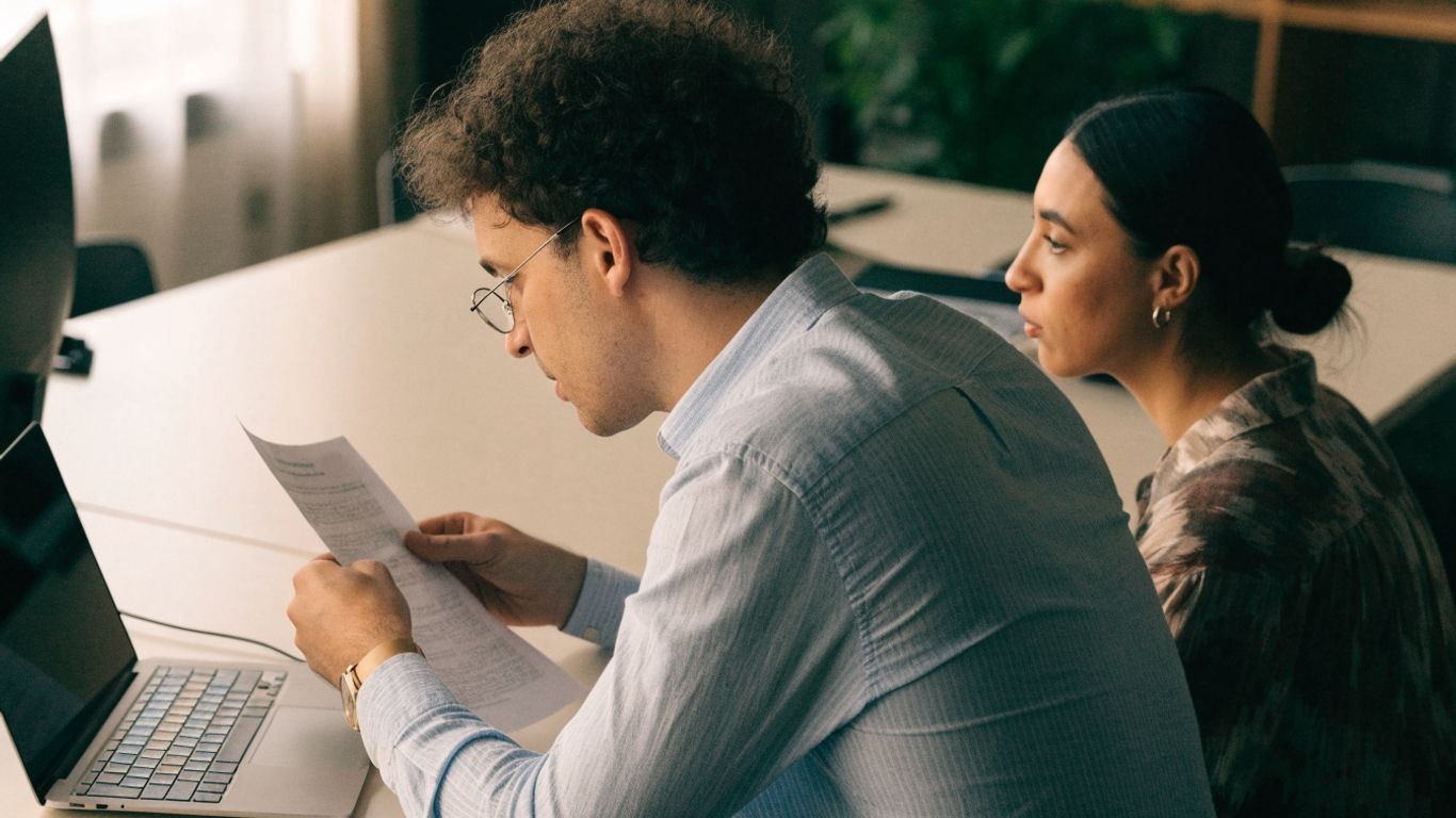 Professional reviewing a draft at a shared office desk