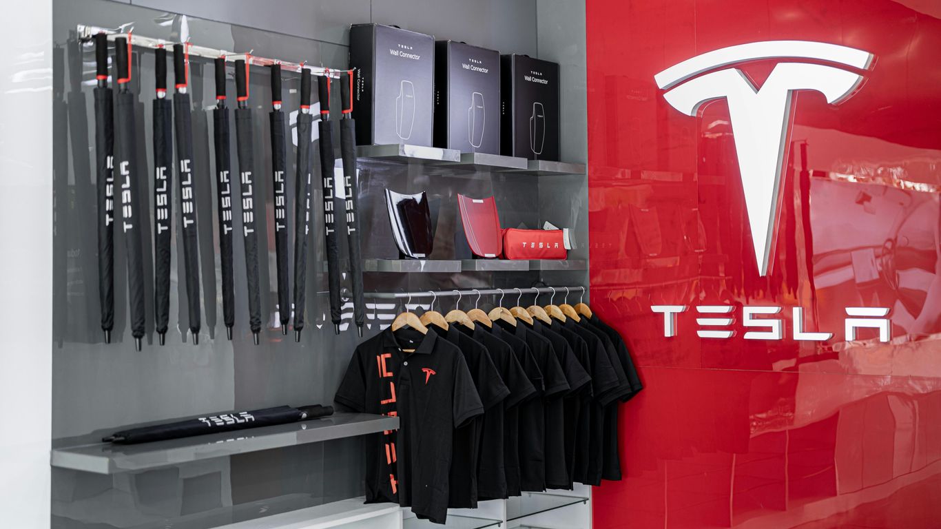 a store with a red wall and a tesla logo on the wall