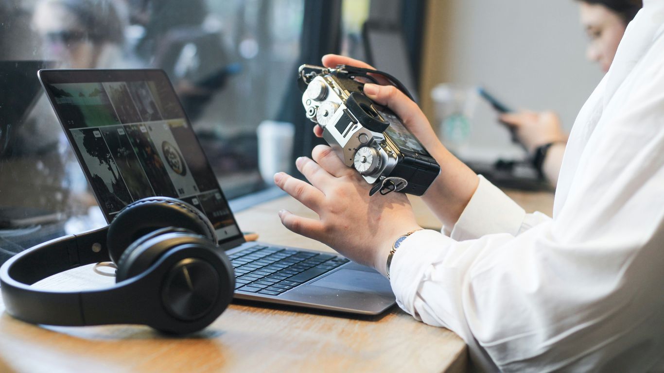 a person sitting at a table with a laptop and headphones