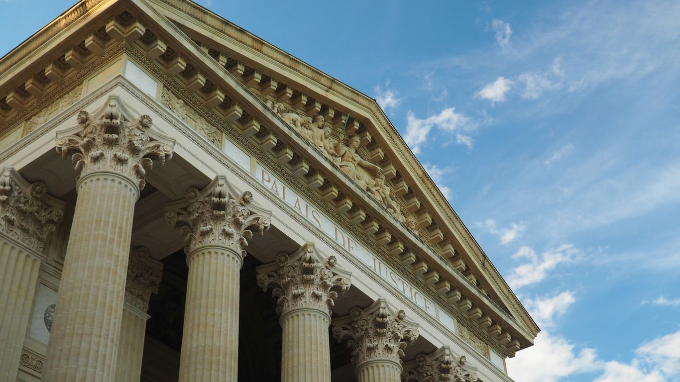 a tall building with columns and a sky background