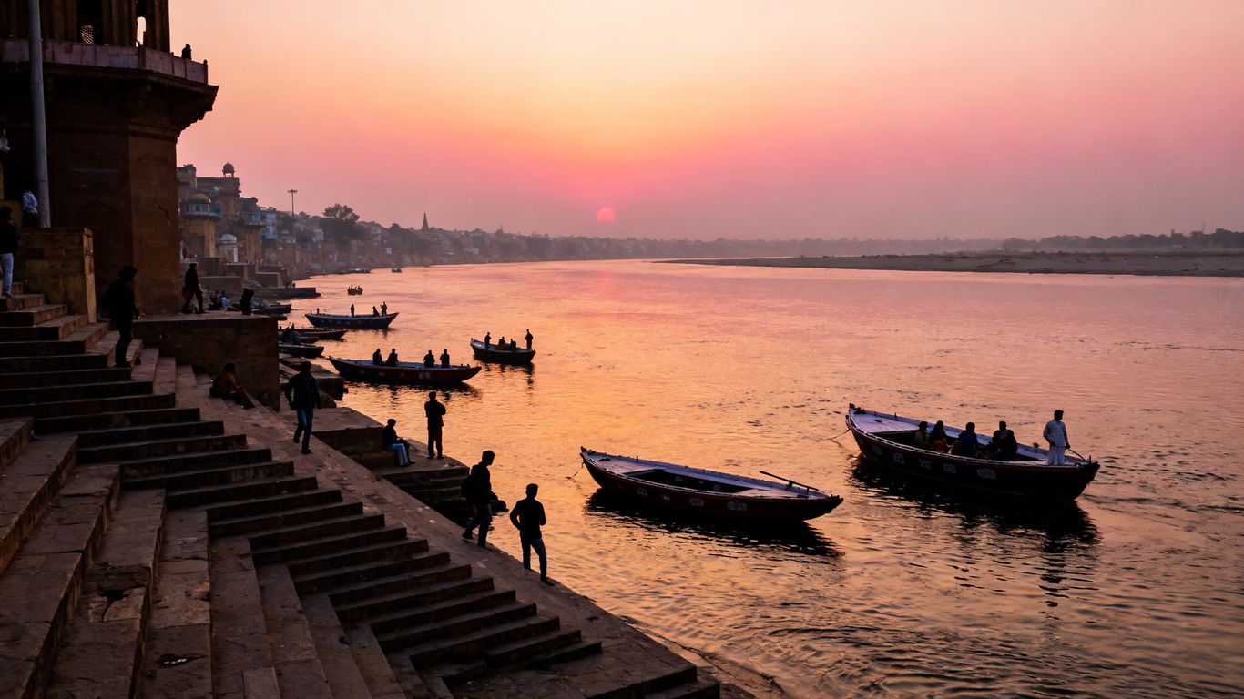 Varanasi ghats at sunrise with Ganges River and boats.