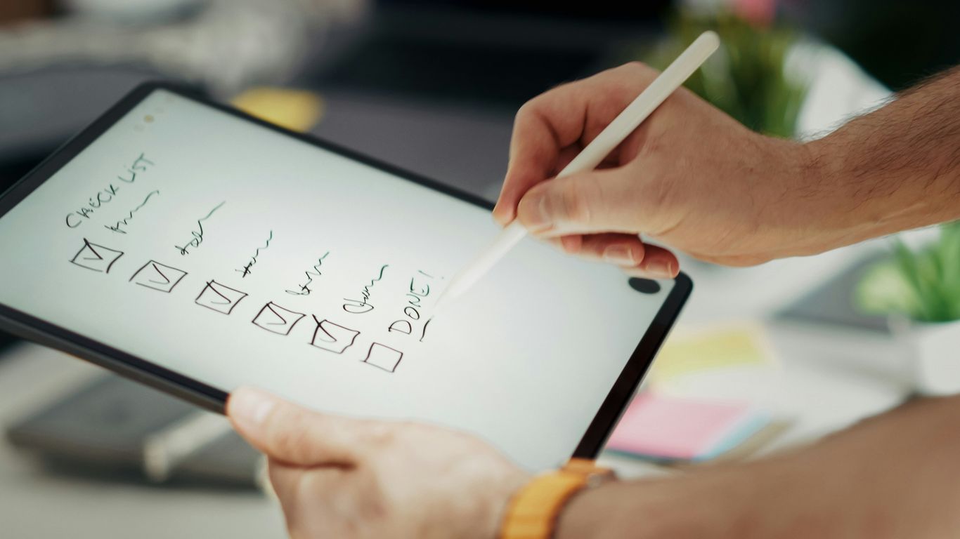 Writing on a checklist with a stylus.