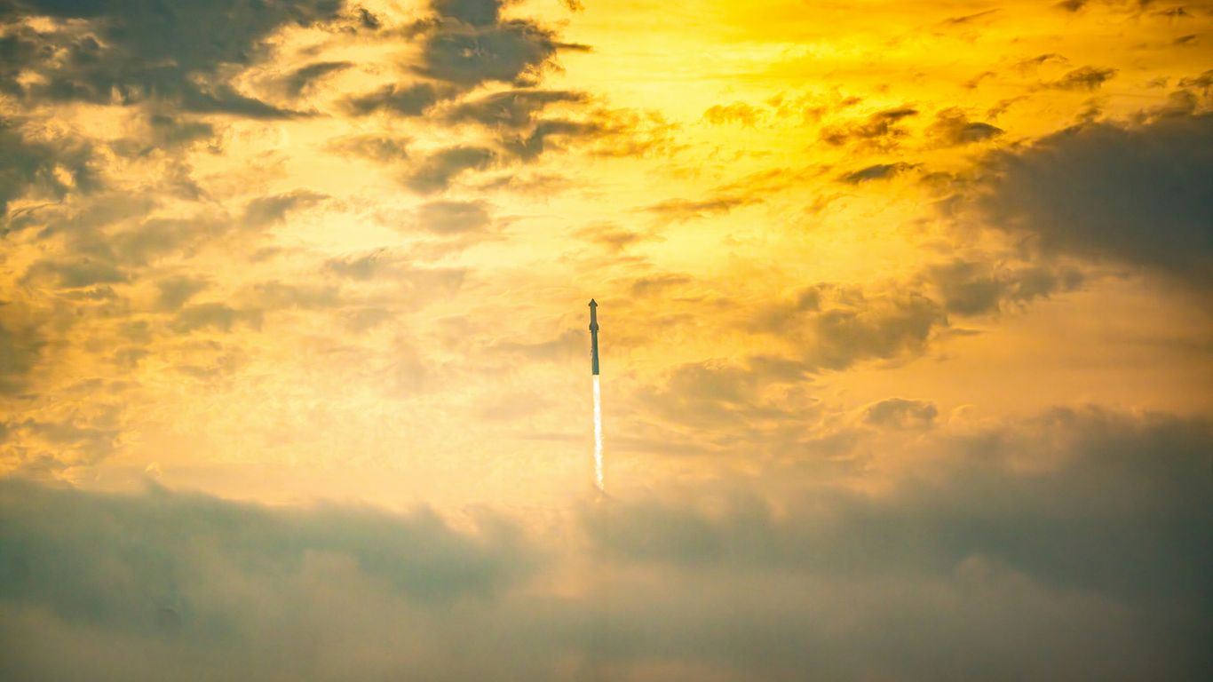 a plane flying through a cloudy sky at sunset