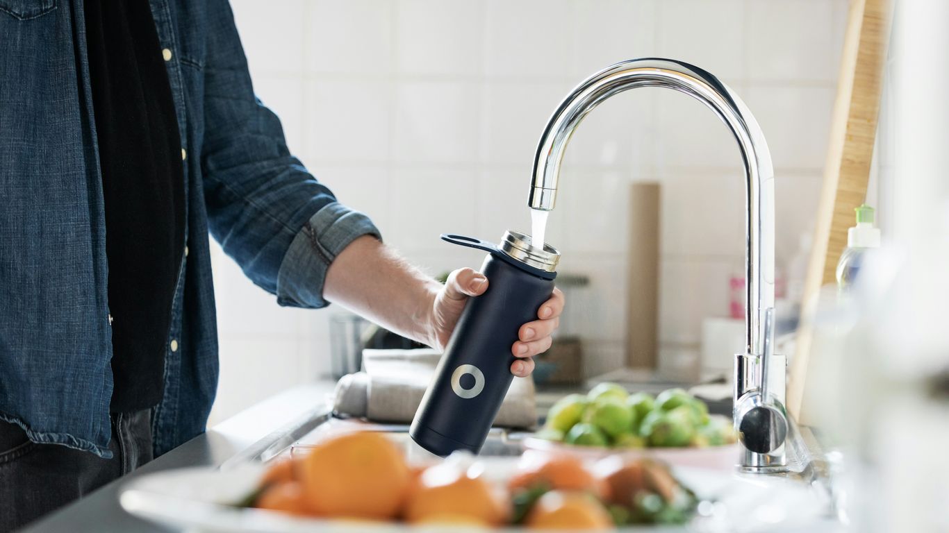 person holding stainless steel faucet